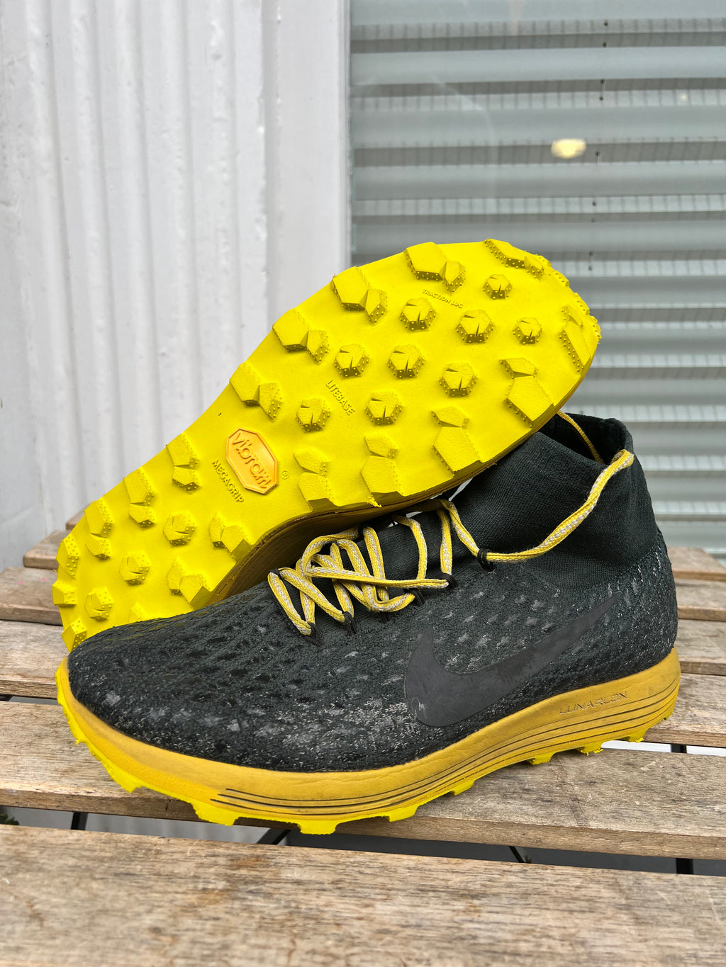 A black Nike running shoe with a bright yellow sole, laces, and outsole, displayed on a wooden surface with the other shoe showing its sole. Running/Trail Resole (extended sizes 49-51) - Sole and Trail